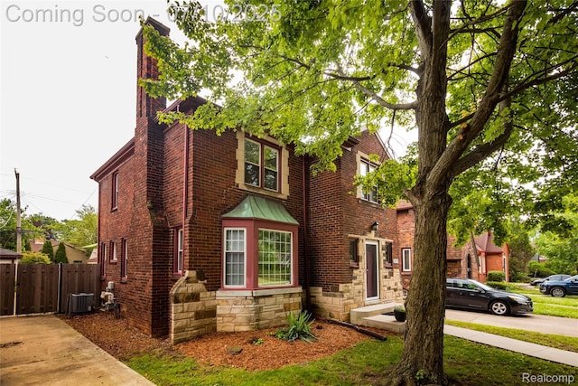3924 Yorkshire Rd, Detroit, MI 48224 - view of front of property with brick siding, a chimney, stone siding, and a standing seam roof