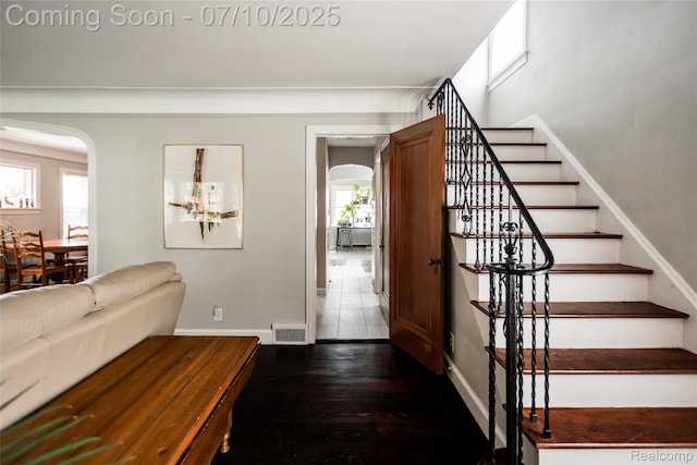 3924 Yorkshire Rd, Detroit, MI 48224 - foyer with arched walkways, stairs, and dark wood-style floors