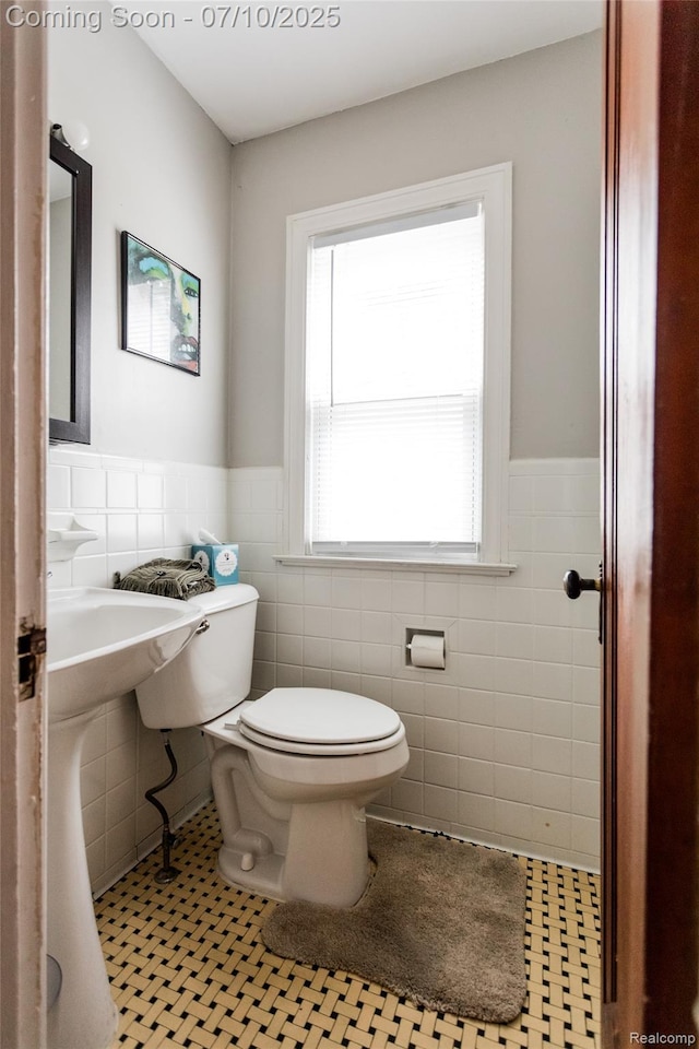 3924 Yorkshire Rd, Detroit, MI 48224 - half bathroom featuring tile walls, a wainscoted wall, and tile patterned flooring