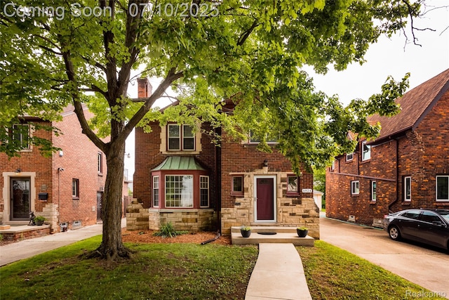 3924 Yorkshire Rd, Detroit, MI 48224 - view of front facade featuring stone siding, a front yard, and a chimney