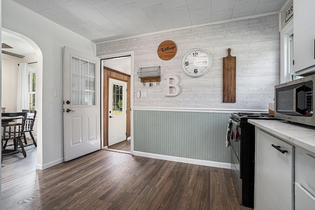 55146 M 51 N, Dowagiac, MI 49047 - foyer entrance featuring arched walkways, dark wood-type flooring, wood walls, and crown molding