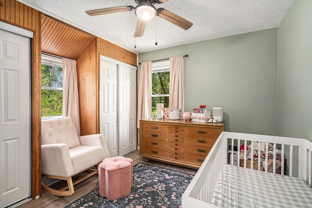 55146 M 51 N, Dowagiac, MI 49047 - bedroom featuring a textured ceiling, wood finished floors, a nursery area, ceiling fan, and wooden walls