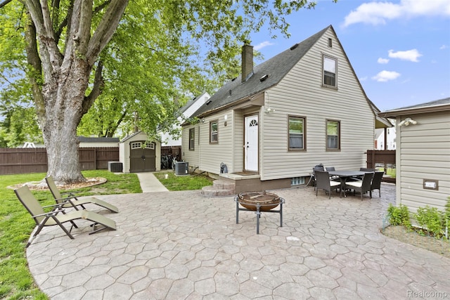 2009 Thomas St, Lincoln Park, MI 48146 - back of house featuring a chimney, a storage shed, outdoor dining area, a patio area, and a fire pit