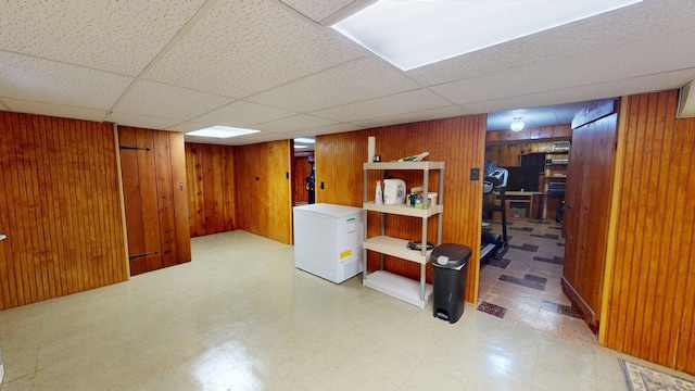 10 Covell Ave NW, Grand Rapids, MI 49504 - finished below grade area with wooden walls, tile patterned floors, fridge, and a drop ceiling