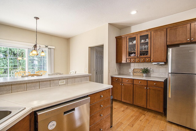 7853 Clydesdale Ave, Kalamazoo, MI 49009 - kitchen featuring stainless steel appliances, brown cabinets, tasteful backsplash, light wood-style floors, and recessed lighting