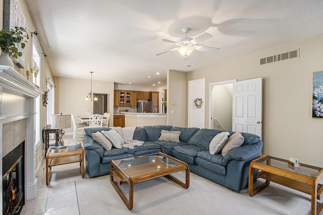7853 Clydesdale Ave, Kalamazoo, MI 49009 - living room with a ceiling fan, a tiled fireplace, a textured ceiling, and recessed lighting