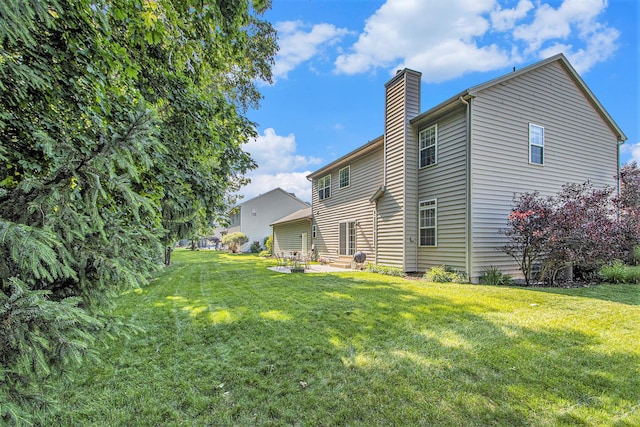 7853 Clydesdale Ave, Kalamazoo, MI 49009 - back of house featuring a chimney, a patio area, and a lawn