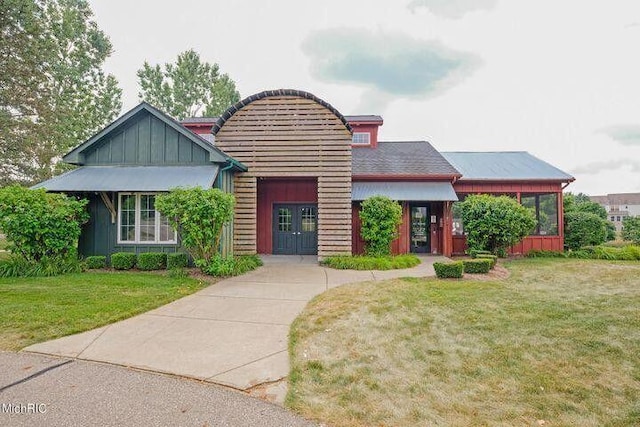 7853 Clydesdale Ave, Kalamazoo, MI 49009 - view of front facade with french doors, a front lawn, and board and batten siding