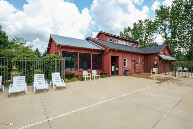 7853 Clydesdale Ave, Kalamazoo, MI 49009 - back of property with board and batten siding, a patio, and a sunroom