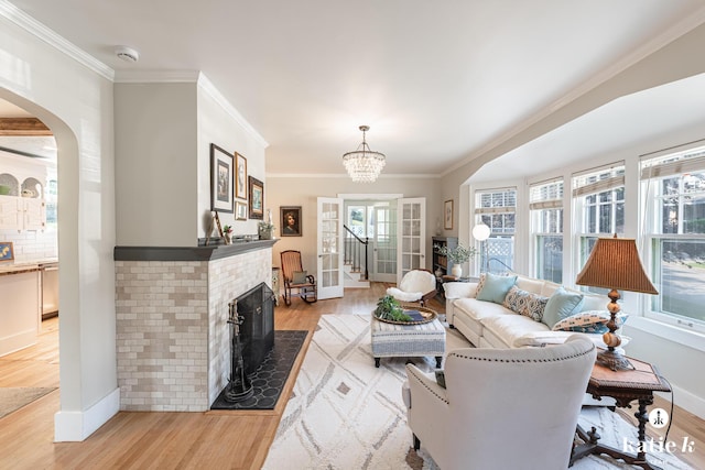 1002 Benjamin Ave SE, Grand Rapids, MI 49506 - living area with light wood finished floors, crown molding, arched walkways, a fireplace, and a chandelier