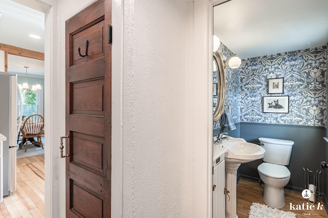 1002 Benjamin Ave SE, Grand Rapids, MI 49506 - bathroom featuring wallpapered walls, wood finished floors, and a chandelier
