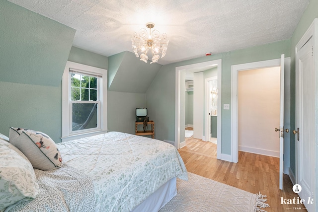 1002 Benjamin Ave SE, Grand Rapids, MI 49506 - bedroom with light wood-style floors, a closet, a chandelier, a textured ceiling, and a spacious closet