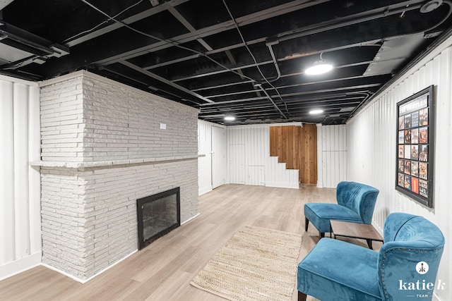 1002 Benjamin Ave SE, Grand Rapids, MI 49506 - living area featuring stairway, wood finished floors, brick wall, and a fireplace