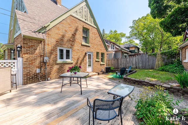 1002 Benjamin Ave SE, Grand Rapids, MI 49506 - rear view of house featuring brick siding, a chimney, a wooden deck, and roof with shingles