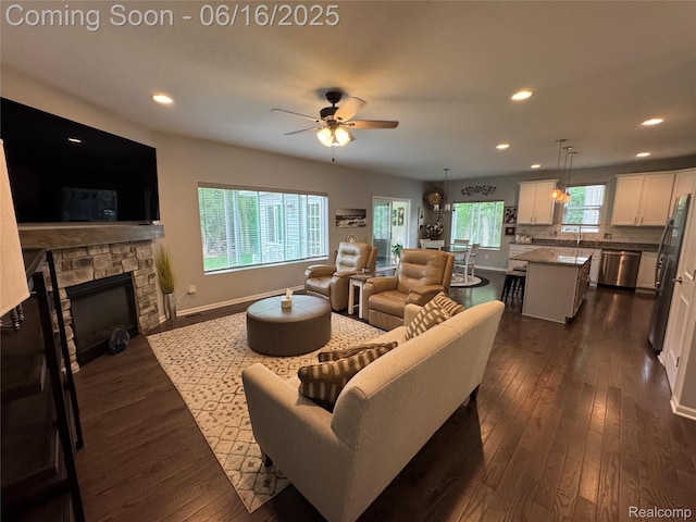 4020 Oak St, Grand Blanc, MI 48439 - living area with dark wood-style flooring, a stone fireplace, recessed lighting, and a ceiling fan