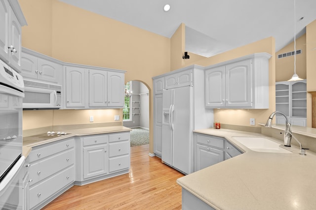6916 Windsong Way, Kalamazoo, MI 49009 - kitchen with white appliances, light wood-type flooring, arched walkways, pendant lighting, and light countertops