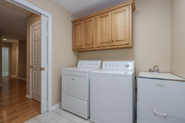 6916 Windsong Way, Kalamazoo, MI 49009 - laundry area featuring independent washer and dryer, cabinet space, and light wood-style floors