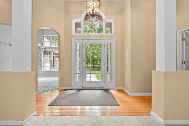 6916 Windsong Way, Kalamazoo, MI 49009 - foyer featuring a chandelier, a towering ceiling, wood-type flooring, and arched walkways