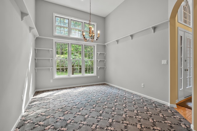 6916 Windsong Way, Kalamazoo, MI 49009 - unfurnished dining area with a chandelier, a high ceiling, and carpet