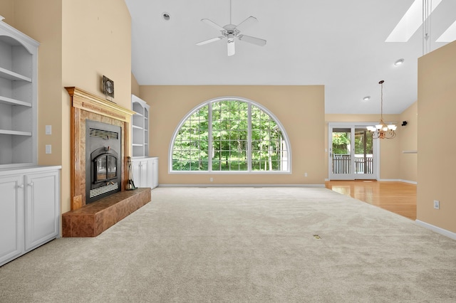 6916 Windsong Way, Kalamazoo, MI 49009 - unfurnished living room featuring carpet flooring, high vaulted ceiling, a chandelier, a ceiling fan, and a tiled fireplace