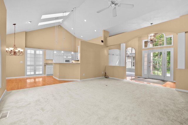 6916 Windsong Way, Kalamazoo, MI 49009 - unfurnished living room featuring a chandelier, high vaulted ceiling, light carpet, a ceiling fan, and a skylight