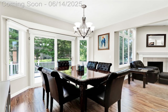 13563 Trotters Ln, Sterling Heights, MI 48313 - dining room with a chandelier, light wood-type flooring, and a tile fireplace