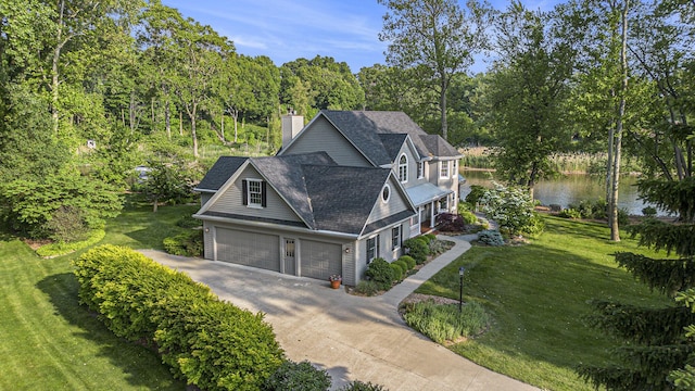 1415 Blackhawk Trl, Benton Harbor, MI 49022 - view of front facade with concrete driveway, a front yard, a water view, and a garage
