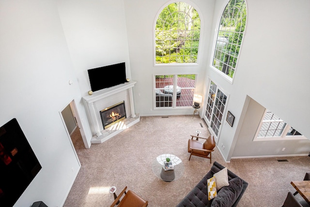 1415 Blackhawk Trl, Benton Harbor, MI 49022 - living room featuring a glass covered fireplace, a towering ceiling, and carpet flooring