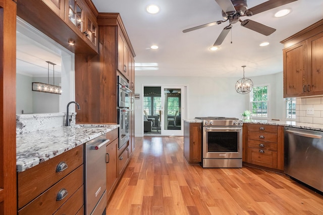 1415 Blackhawk Trl, Benton Harbor, MI 49022 - kitchen with appliances with stainless steel finishes, brown cabinets, a chandelier, light wood-style flooring, and recessed lighting