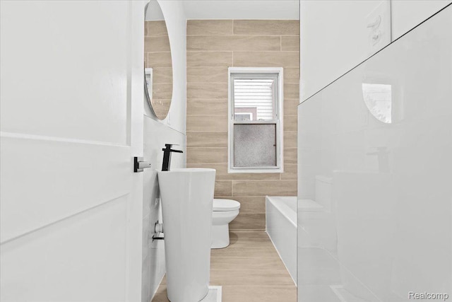 475 Algonquin St, Detroit, MI 48215 - bathroom featuring tile walls and a tub to relax in