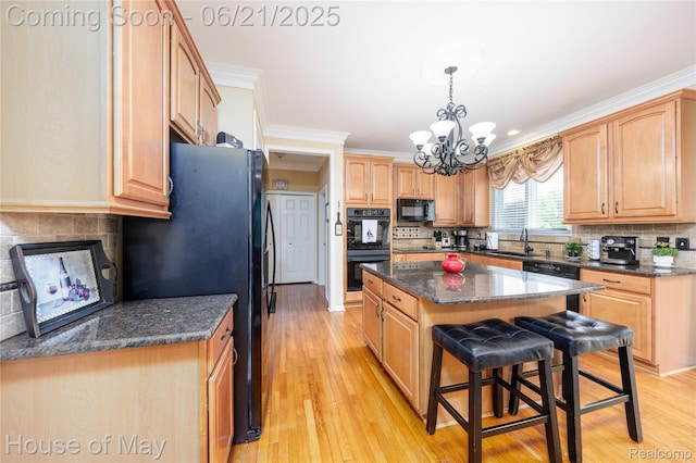 1768 Carriage Hl, Commerce Twp, MI 48382 - kitchen featuring black appliances, a kitchen island, a chandelier, crown molding, and a breakfast bar area