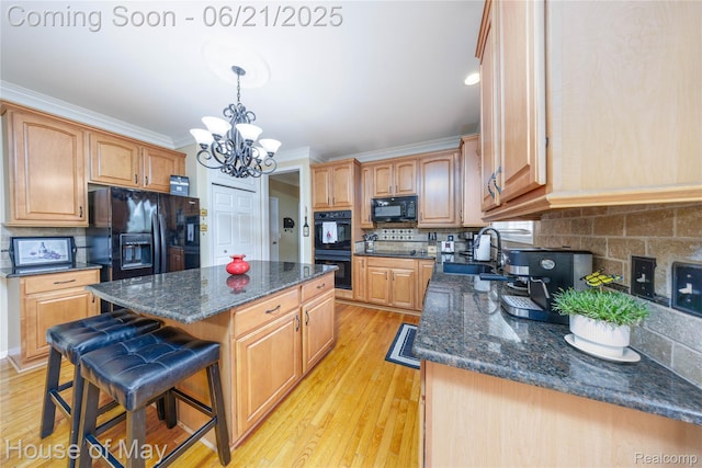 1768 Carriage Hl, Commerce Twp, MI 48382 - kitchen featuring black appliances, a kitchen island, a chandelier, light wood-style flooring, and decorative backsplash