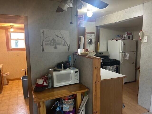 844 N Oak St, Evart, MI 49631 - kitchen with white appliances, a ceiling fan, and light floors