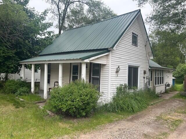 844 N Oak St, Evart, MI 49631 - view of side of property featuring covered porch and a metal roof