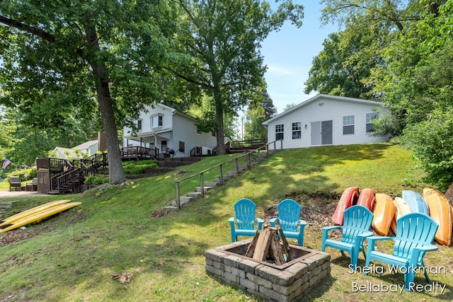 1725 Ottawa Trl, Hastings, MI 49058 - view of green lawn featuring a fire pit, stairway, a wooden deck, and a playground