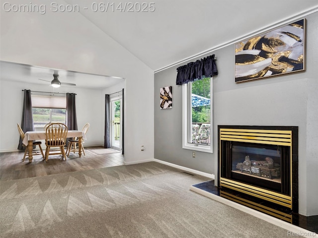 4960 Paula Ave, Clarkston, MI 48346 - living area with carpet flooring, healthy amount of natural light, lofted ceiling, a glass covered fireplace, and a ceiling fan
