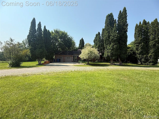 6715 Elizabeth Lake Rd, Waterford, MI 48327 - view of green lawn with driveway and an attached garage