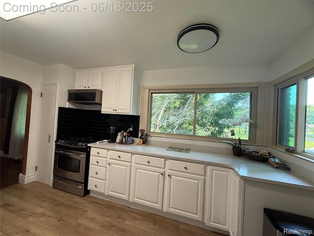 6715 Elizabeth Lake Rd, Waterford, MI 48327 - kitchen with appliances with stainless steel finishes, light countertops, healthy amount of natural light, and white cabinets