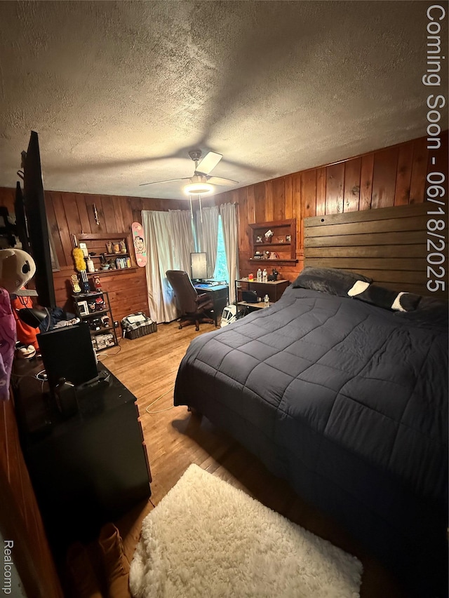 6715 Elizabeth Lake Rd, Waterford, MI 48327 - bedroom featuring wood walls, a textured ceiling, light wood-type flooring, and a ceiling fan