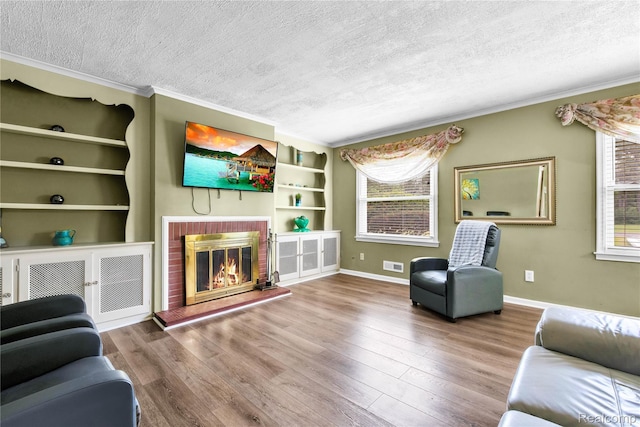24710 Lathrup Blvd, Southfield, MI 48075 - living room with a textured ceiling, ornamental molding, built in features, wood finished floors, and a brick fireplace