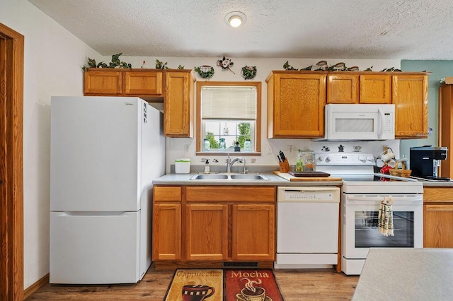 66291 M-62, Edwardsburg, MI 49112 - kitchen with white appliances, a textured ceiling, light countertops, light wood-type flooring, and brown cabinets