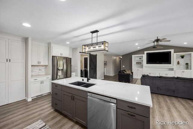 1153 S Edgar Rd, Mason, MI 48854 - kitchen with appliances with stainless steel finishes, wood finished floors, white cabinets, recessed lighting, and vaulted ceiling