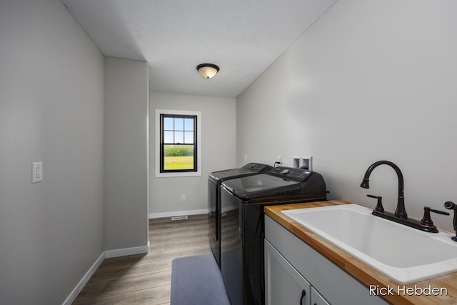 1153 S Edgar Rd, Mason, MI 48854 - laundry room featuring washing machine and clothes dryer, light wood-style floors, and cabinet space