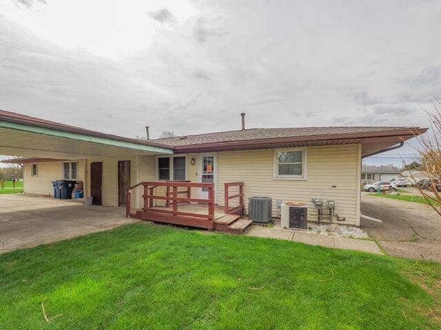 1314 Magnolia St, Kalamazoo, MI 49048 - back of house with a lawn, a wooden deck, and a carport