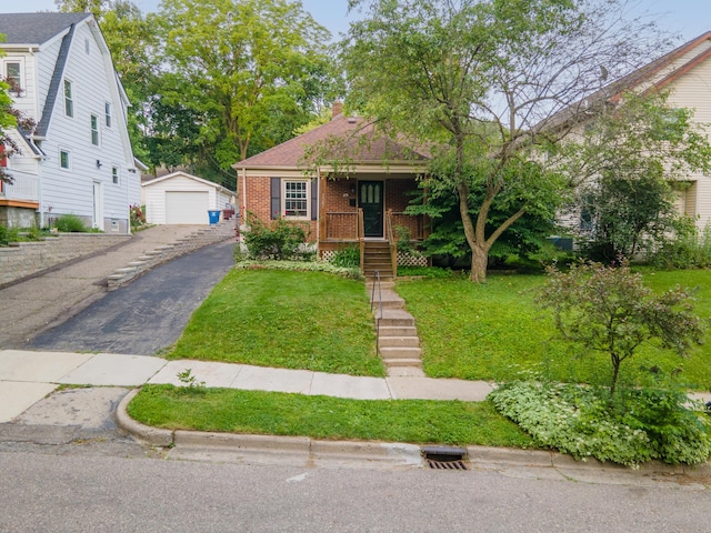1307 Edgewood Ave, Ann Arbor, MI 48103 - bungalow with an outbuilding, a detached garage, a front lawn, brick siding, and a porch