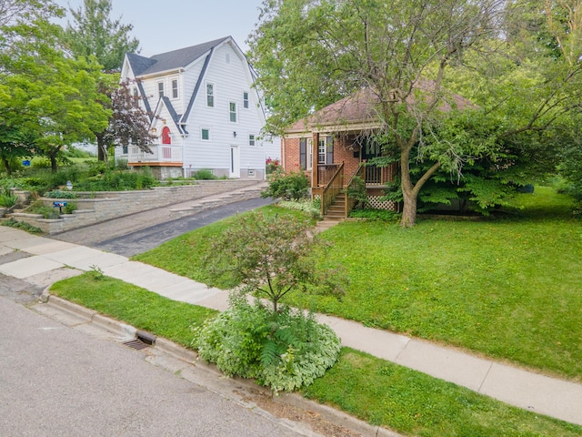 1307 Edgewood Ave, Ann Arbor, MI 48103 - dutch colonial featuring a front yard, brick siding, covered porch, and a gambrel roof