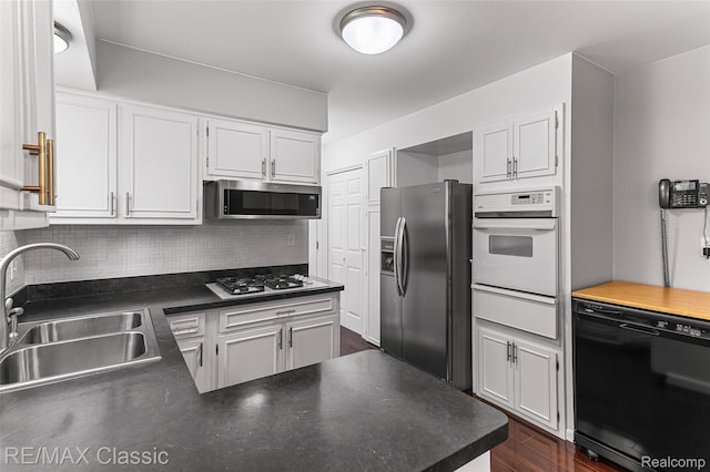 1915 Treadwell St, Westland, MI 48186 - kitchen with stainless steel appliances, a warming drawer, decorative backsplash, dark wood-type flooring, and white cabinets