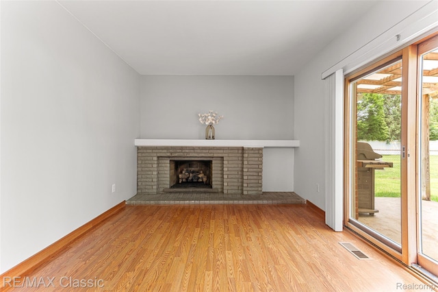 1915 Treadwell St, Westland, MI 48186 - unfurnished living room featuring light wood finished floors and a brick fireplace