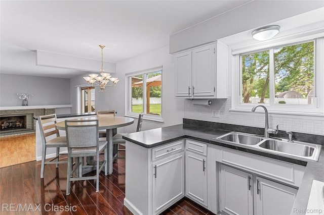 1915 Treadwell St, Westland, MI 48186 - kitchen featuring dark wood-style floors, dark countertops, tasteful backsplash, and a chandelier