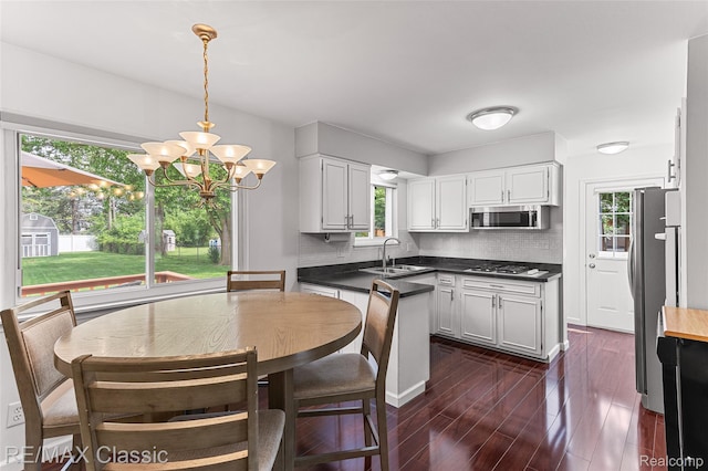 1915 Treadwell St, Westland, MI 48186 - kitchen with appliances with stainless steel finishes, plenty of natural light, a chandelier, and tasteful backsplash